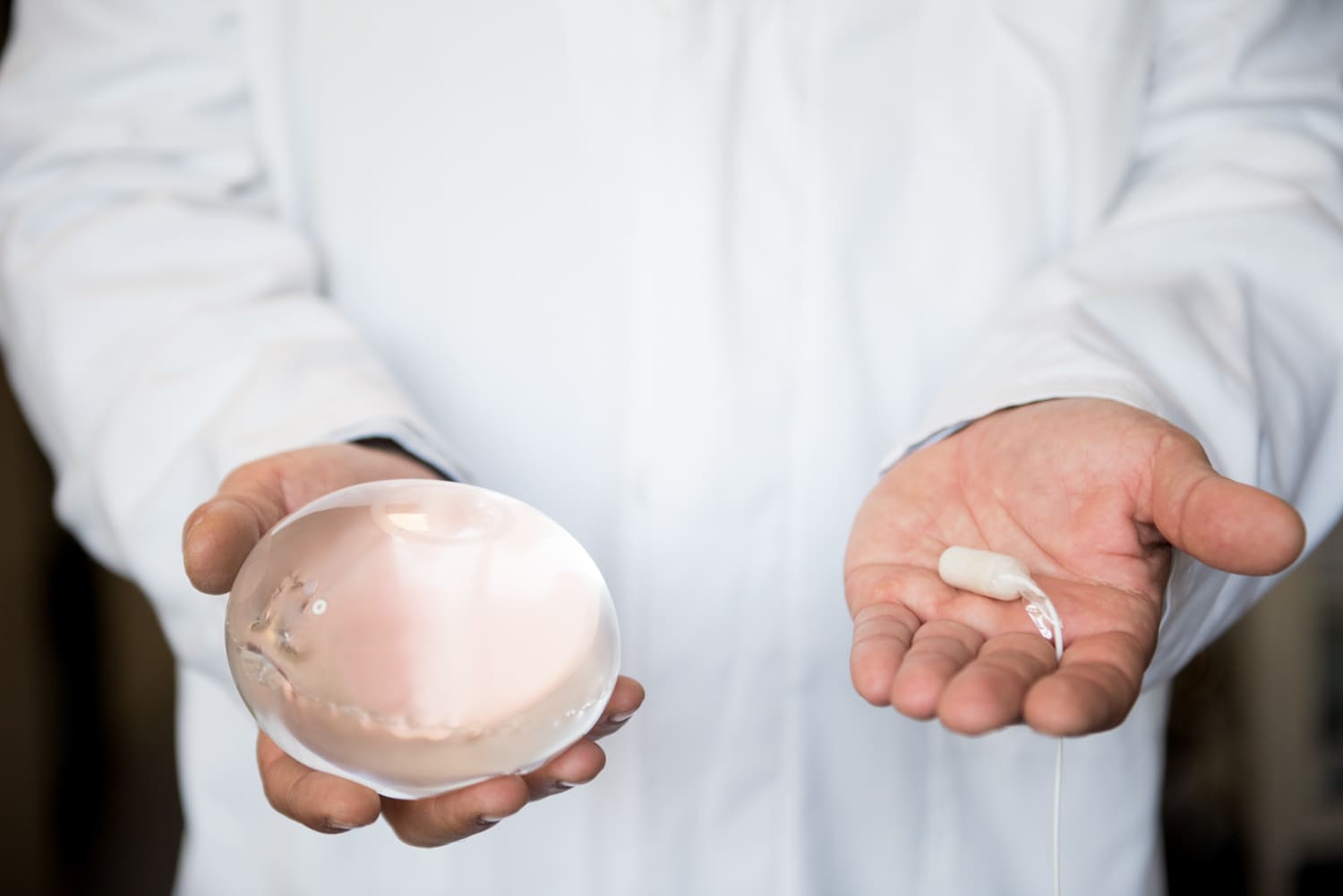 A Doctor holding both the Allurion Gastric Balloon and Capsule in his hands