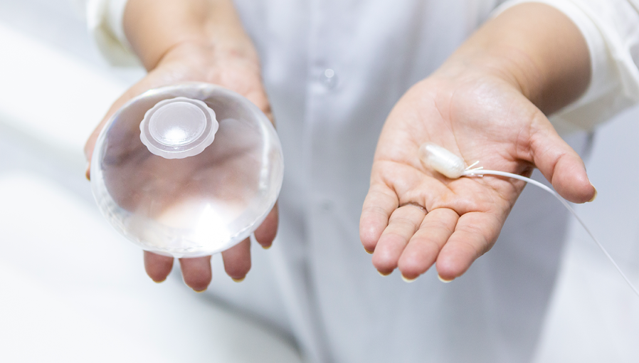 Un medico che tiene in mano il palloncino gastrico e la capsula Allurion