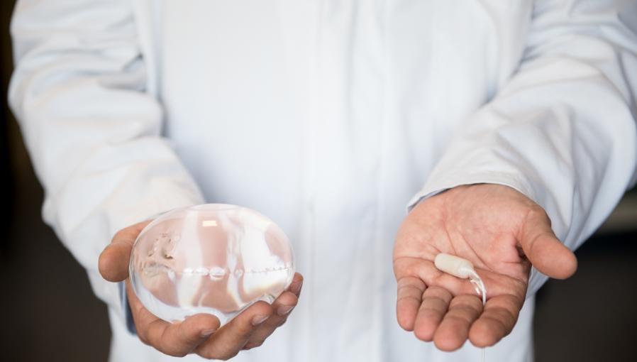 A Doctor holding the Allurion Gastric Balloon and Capsule in his hands