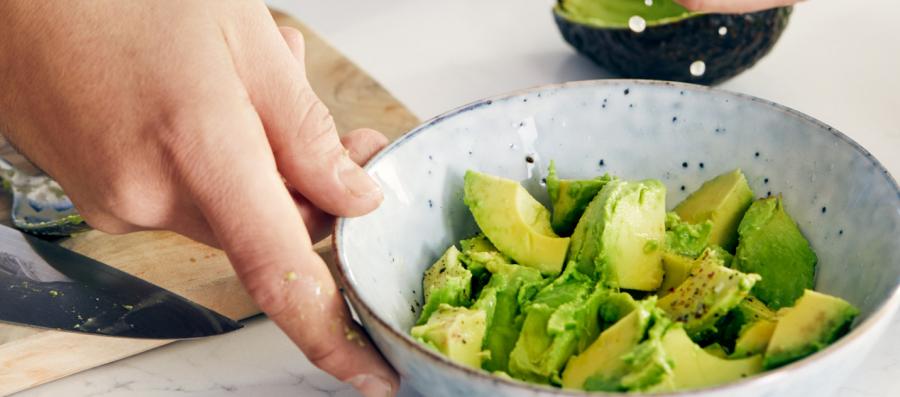 Preparing avocado salad in a bowl as a part of diet meal program